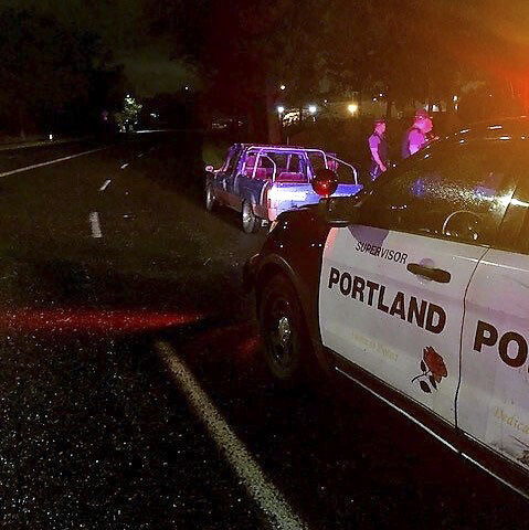 PPB vehicle with lights flashing behind a pickup truck. Photo courtesy Portland Police Bureau