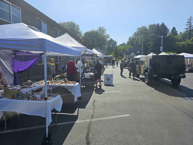 Vendors were busy Thursday at the La Center Farmer’s Market. On this day, it was also a celebration of the military, with a U.S. Army band performing and a display of military vehicles. Photo by Paul Valencia