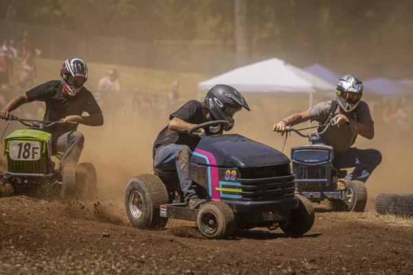 Will Smith, Wyatt Peterson and Dave O’Brien battle it out in the Territorial Days Lawn Mower Races. Photo by Mike Schultz