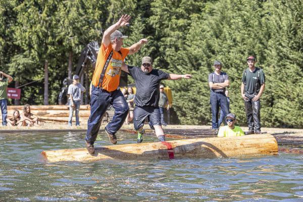 Jeff Fetter and Mike Truong participate in the log roll competition at the Territorial Days Log Show Saturday. Photo by Mike Schultz
