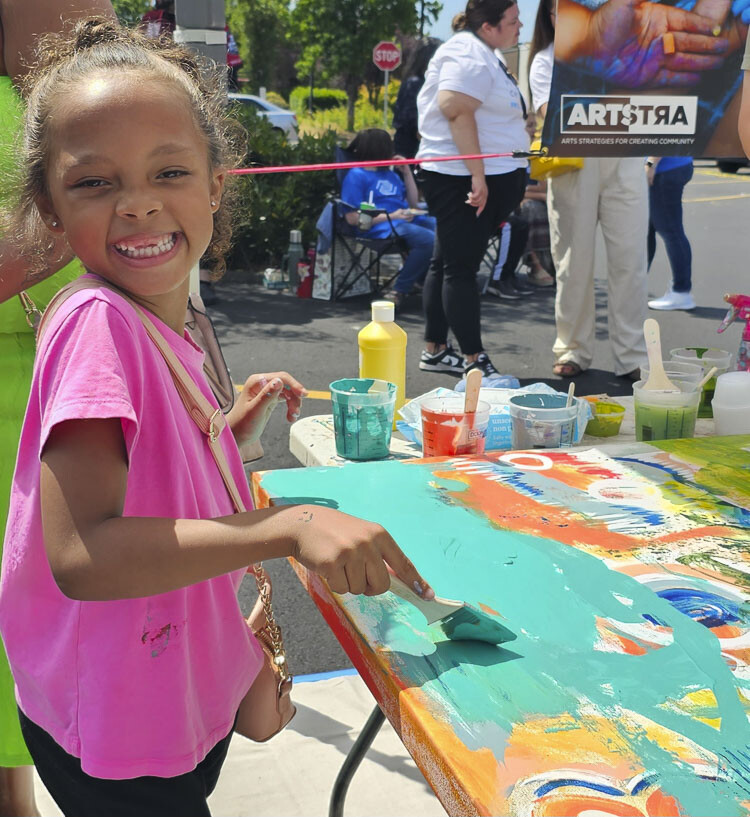 Kamiiyah, 6, was one of dozens of artists who helped with an original piece of work during Uplift! on Tuesday. Photo by Paul Valencia