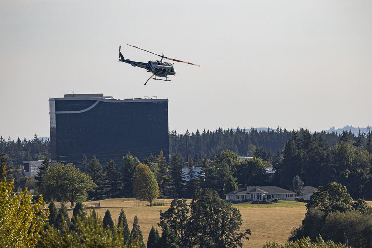 A helicopter is shown here while flying back and forth over La Center Wednesday afternoon to pull water from the East Fork of the Lewis River. The ilani Casino Hotel can be seen in the background. Photo by Mike Schultz
