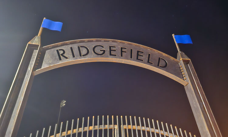 The gate that welcomes fans to Ridgefield’s football stadium, shown Tuesday night just before the stadium lights came on for Ridgefield’s Midnight Madness football practice. Photo by Paul Valencia