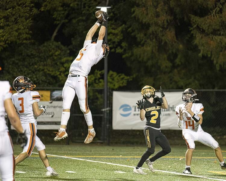 Holden Bea is known for his talent as a quarterback who can pass and run effectively, but he also can play defense. Here he is, as a safety, leaping high for an interception Friday night. Photo by Mike Schultz