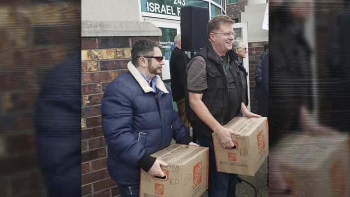 Political consultant Andrew Stevens, left, and Glen Morgan, founder of the "We the Governed" website, carry boxes of Initiative 2117 signatures during Tuesday afternoon's drop-off event at the Secretary of State's office in Tumwater. Photo by Brett Davis