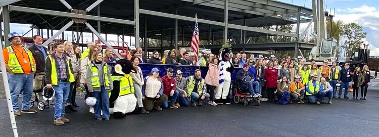 Attendees of Thursday’s ceremony gather with the signed beam to commemorate the milestone. Photo courtesy Clark College Communications