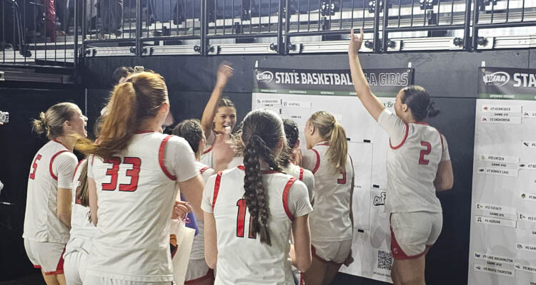 The Camas Papermakers celebrate their win Thursday by adding their name to the next spot on the state tournament bracket. Photo by Paul Valencia