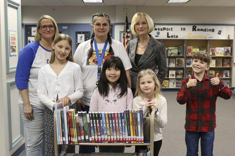 Shown here (left-to-right) are Kelli Eldridge (Gause Boosters president), Nora Persons (5th grade student), Perri Prince (Gause Library media instructor), Ema Sunada (2nd grade student), Mary Templeton (superintendent), Avery Williams (kindergarten student) and Jack Masters (3rd grade student) stand with a cart of donated books in the Gause library. Photo courtesy Washougal School District