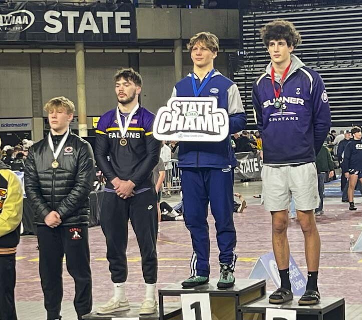 JJ Schoenlein of Skyview holds up the state champ sign on the podium Saturday night. He won his second consecutive state title. Skyview won four individual championships at Mat Classic, and Clark County had a total of seven champions in boys and girls wrestling. Photo courtesy Julian Williams