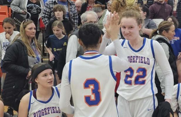 Ridgefield senior Elizabeth Swift (22) celebrates with teammate Savannah Chanda after they helped the Spudders advance to the state round of 12 on Friday. Photo by Paul Valencia
