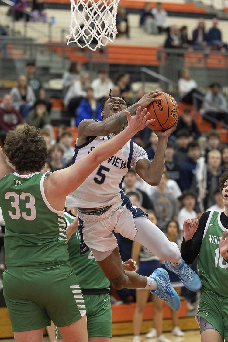 Skyview’s Demaree Collins drives through traffic toward the basket against Woodinville. Collins would make the play of the night on defense, getting a steal in the closing seconds to help secure a three-point win for Skyview. Photo by Mike Schultz