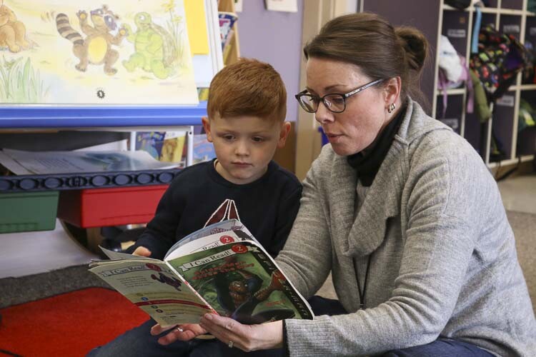 Four-year-old student listens to a book read aloud by a staff member in Transition to Kindergarten class. Photo courtesy Washougal School District