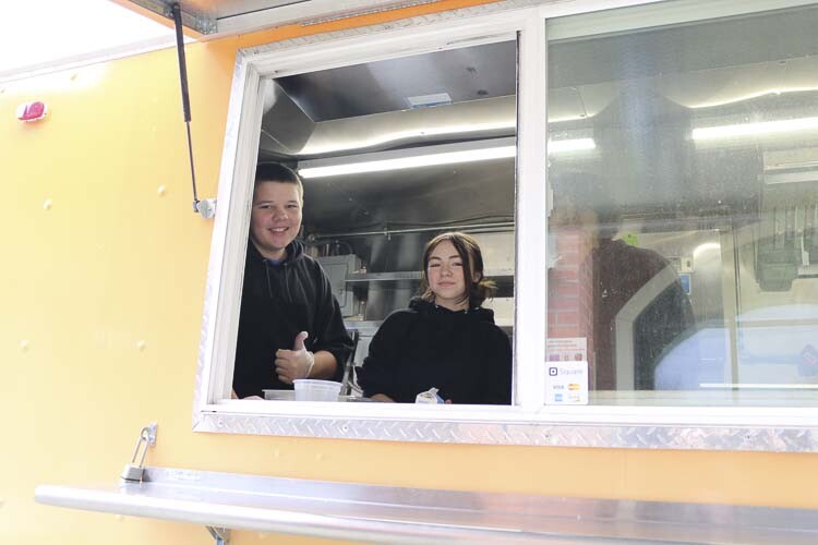 Jackson Lockard ( left) and Baylee Wallway (right) serve meals out of the food truck window. Photo courtesy Washougal School District