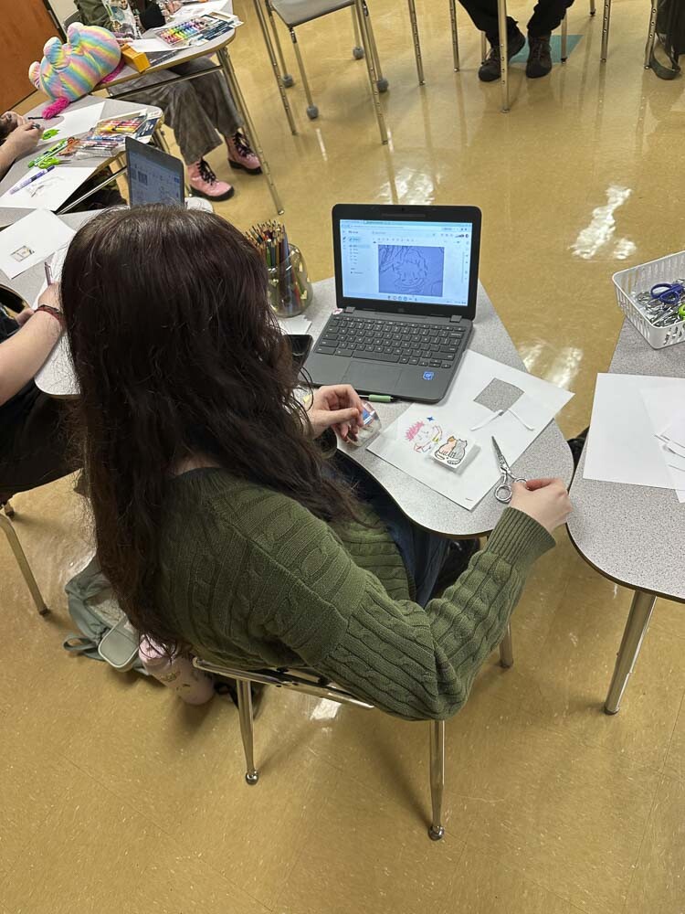 Riley Williams uses reference material to create custom sticker designs in craft club. Photo courtesy Washougal School District