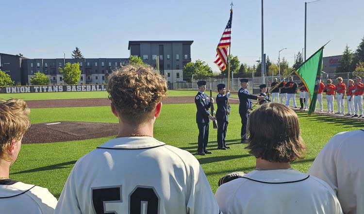 Players from Union and Battle Ground stand before the color guard during the national anthem Tuesday before their Honor Game, in recognition of veterans, first responders, and educators. Photo by Paul Valencia
