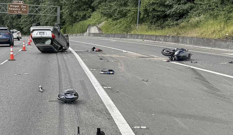 An overturned silver Subaru and a downed Yamaha “sport” motorcycle is shown on the freeway. Skid marks, roadway gouges, clothing, and debris can be seen scattered about. Photo courtesy Portland Police Bureau