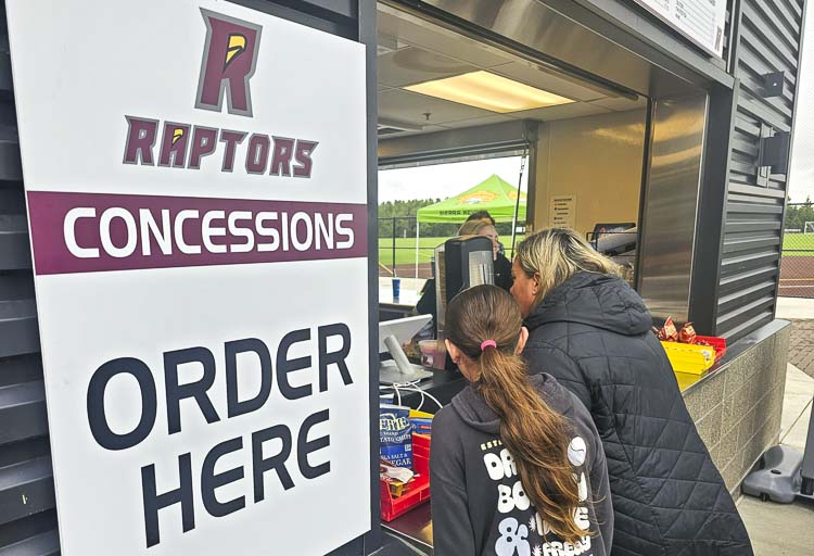Fans order food at the Ridgefield Raptors concession stand on Tuesday. Every home game on a Tuesday is $3 Tuesday at the Ridgefield Outdoor Recreation Complex, with several items on sale for $3. Photo by Paul Valencia
