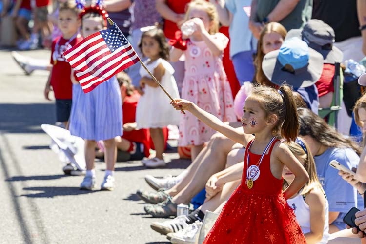 Charlotte Caudillo proudly displays her flag while watching the Fourth of July parade in Ridgefield on Thursday. Photo by Mike Schultz