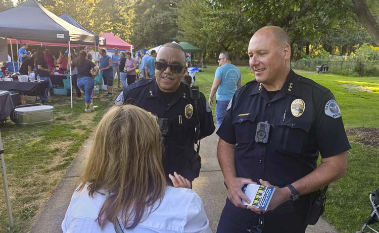 Troy Price, left, deputy chief of police, and Jeff Mori, chief of police, talk to a woman during a National Night Out event at LeRoy Haagen Memorial Park in Vancouver on Wednesday. Photo by Paul Valencia