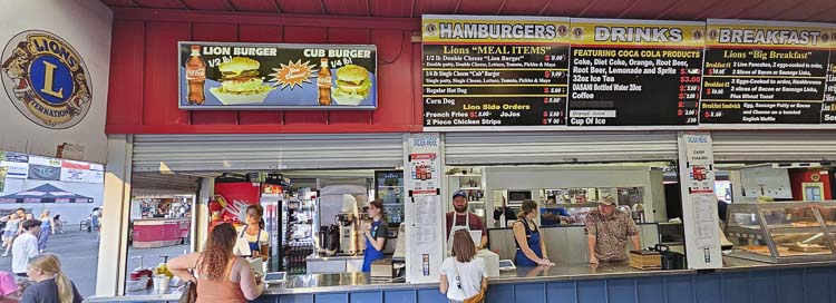 The food booth has a slow period usually around 7 p.m., when the grandstand show begins at the Clark County Fair every night, but otherwise, it is crazy busy. Last year the Ridgefield Lions Club food booth cooked 4,000 burgers during the fair. Photo by Paul Valencia