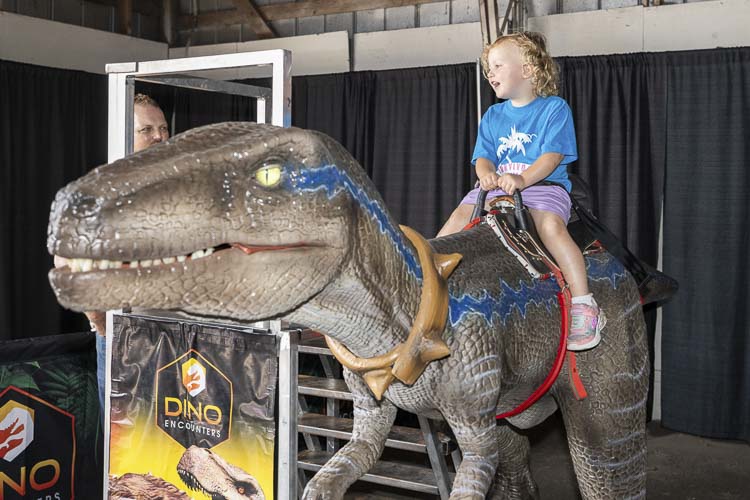 Rayanna Dresser of Battle Ground loved her time on the dinosaur ride Friday at the Clark County Fair. Photo by Mike Schultz