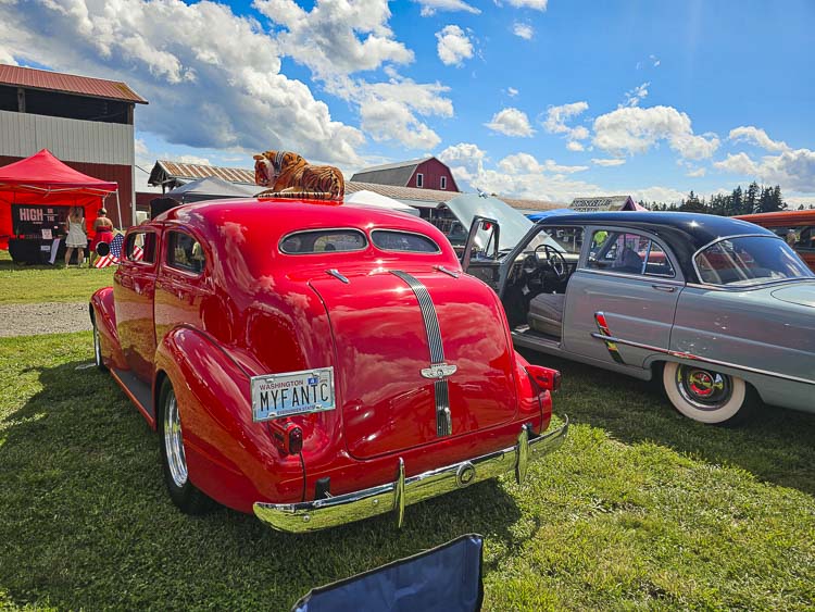 A beautiful red car, a tiger, on a farm, with partly cloudy skies. Naturally, right? Photo by Paul Valencia