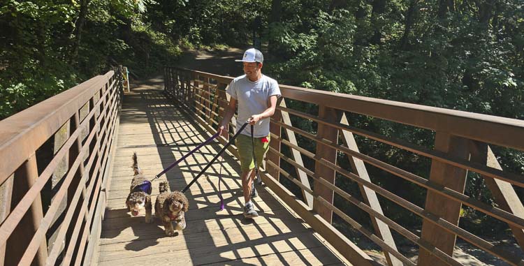 Jose Mateo said all dogs, such as Bamou and Tambou, need exercise. Not everyone can get away from work or has the physical abilities to take dogs on long walks. That is why he opened his business, He Walks Dogs. Photo by Paul Valencia