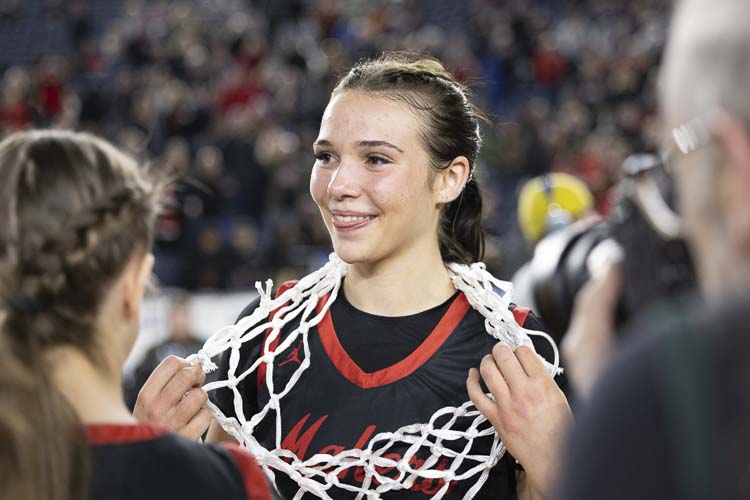 Kendall Mairs wears one of the state championship nets after the Camas Papermakers won the Class 4A title in March in the Tacoma Dome. This school year, the multi-sport athlete is focusing on volleyball, the sport she will play in college. Photo by Mike Schultz