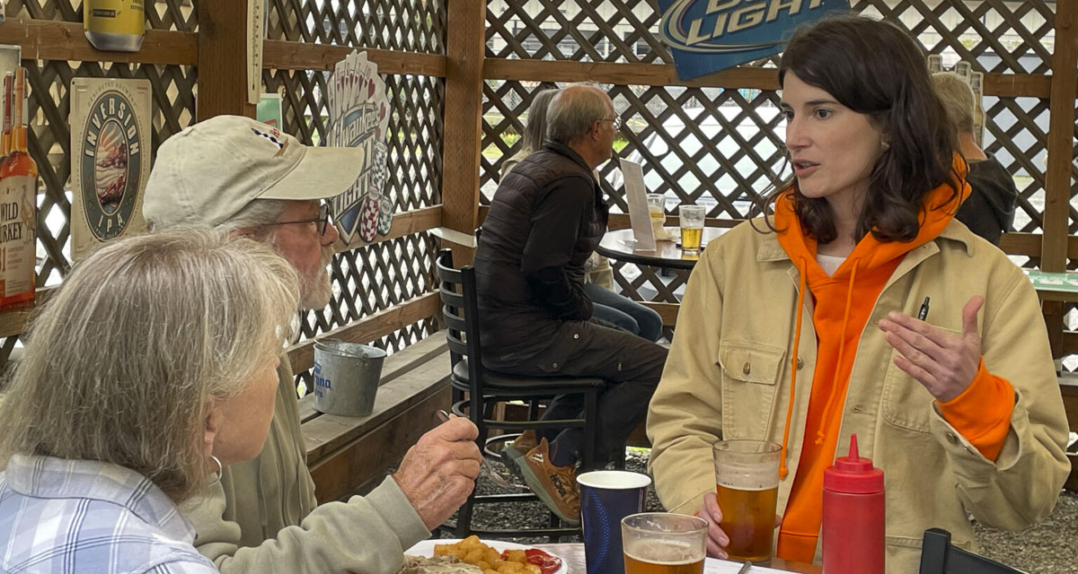 Democratic U.S. Rep. Marie Gluesenkamp Perez speaks to Fran Walling (left) and Homer Terry on the patio of the Fat Moose Bar & Grill in Woodland. The first-term congresswoman is in a tough re-election fight in 2024 for the 3rd Congressional District and won’t say which presidential candidate she voted for. Photo courtesy Jerry Cornfield/Washington State Standard