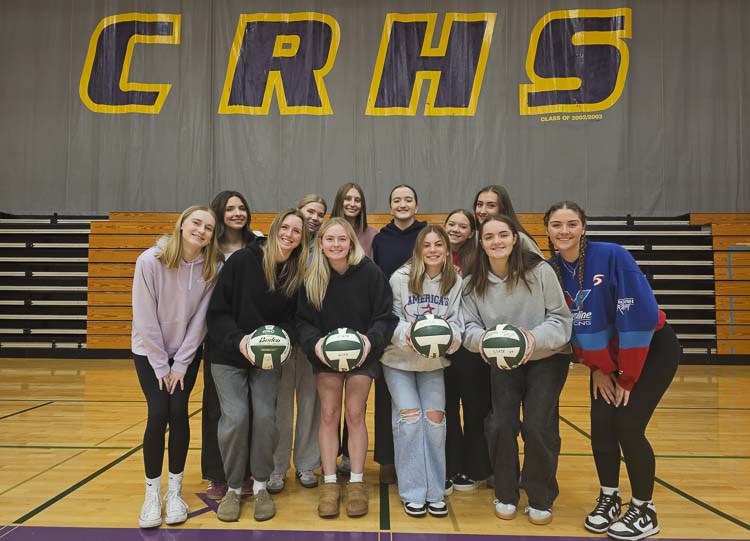 The Class 2A state volleyball championship team from Columbia River holds up championship match volleyballs from 2021, 2022, 2023, and 2024. Yes, the Rapids have now won four consecutive state titles. Photo by Paul Valencia