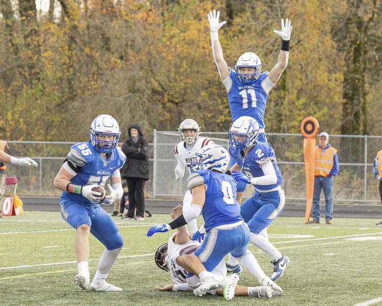 La Center’s Mason Klein (55) gets the interception while teammate Parker McKinney jumps to celebrate. Photo by Mike Schultz