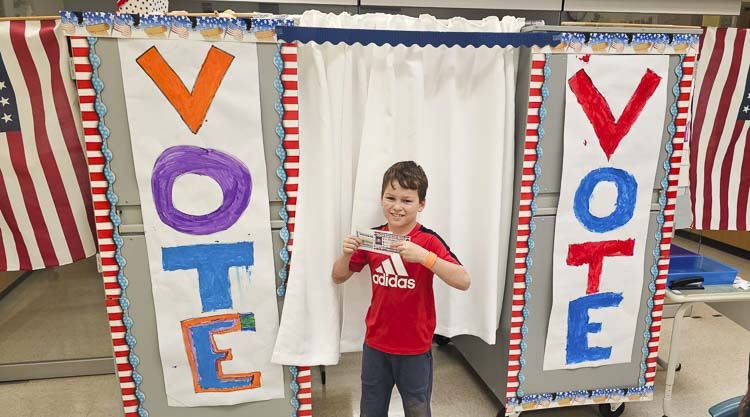 Grady Englebart shows off his voting registration card in Salmon Creek Elementary School’s election for a third-grade mascot. Photo by Paul Valencia