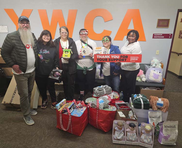 Employees of Taylor Morrison as well as YWCA workers celebrate the $1,000 worth of donations to The Holiday Shop at the YWCA Clark County. The shop allows for families in need to do their Christmas shopping. Photo by Paul Valencia