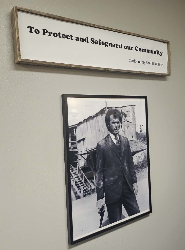 Showcasing a bit of Sheriff John Horch’s sense of humor, a picture of Dirty Harry hangs under words describing the mission of the Clark County Sheriff’s Office. Photo by Paul Valencia