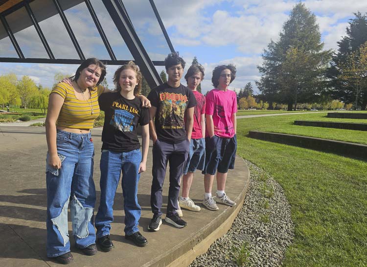 On the left are Viv Lovell and Mia Knesal-Walker, who form the band Poorly Executed. They are standing next to Cane Corso band members Liam Brotherton, Collin McMaken, and Benjamin Knudson Vasquez. Both bands will be performing in the Clark County Battle of the Bands on May 31. Photo by Paul Valencia