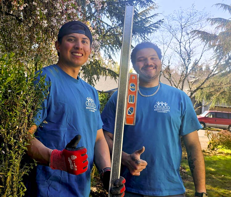 Miguel Moreno and Jukwon Shaffer of Rick’s Custom Fencing and Decking give the thumbs-up sign as they work on a new fence for Kayla Susick, who is battling cancer. Photo by Paul Valencia